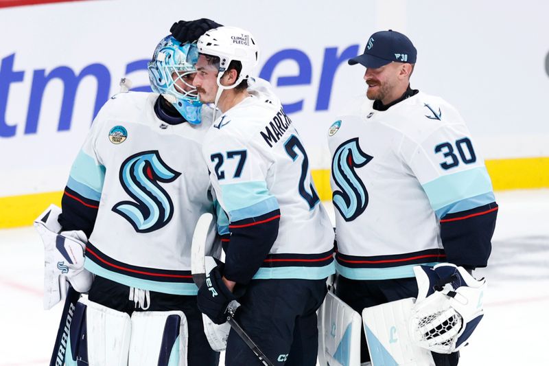 Oct 23, 2025; Winnipeg, Manitoba, CAN; Seattle Kraken goaltender Joey Daccord (35), Seattle Kraken left wing Mason Marchment (27) and Seattle Kraken goaltender Matt Murray (30) celebrate their victory against the Winnipeg Jets at Canada Life Centre. Mandatory Credit: James Carey Lauder-Imagn Images