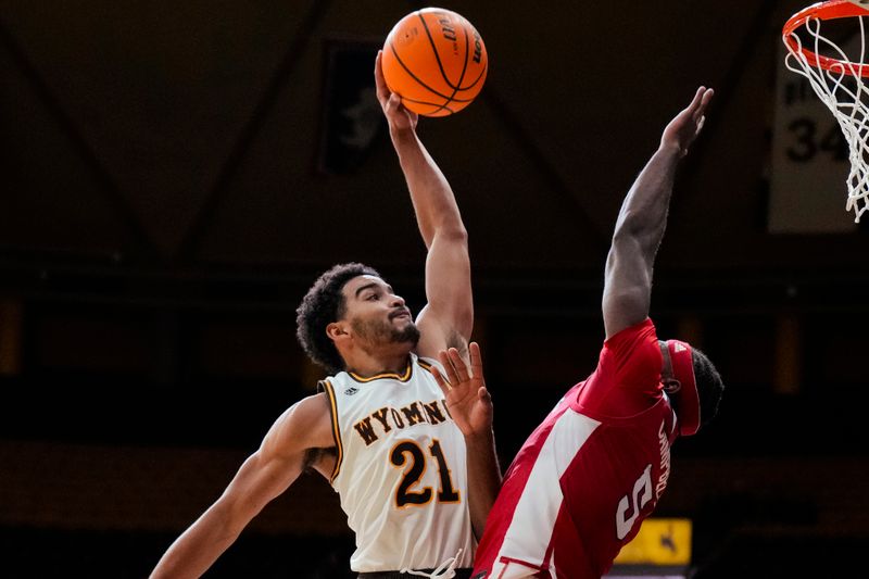 Jan 31, 2023; Laramie, Wyoming, USA; Wyoming Cowboys guard Noah Reynolds (21) has his shot blocked by Fresno State Bulldogs guard Jordan Campbell (5) during the second half at Arena-Auditorium. Mandatory Credit: Troy Babbitt-USA TODAY Sports