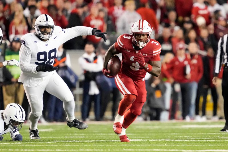 Oct 26, 2024; Madison, Wisconsin, USA;  Wisconsin Badgers running back Tawee Walker (3) rushes with the football in front of defensive tackle Coziah Izzard (99) during the second quarter at Camp Randall Stadium. Mandatory Credit: Jeff Hanisch-Imagn Images