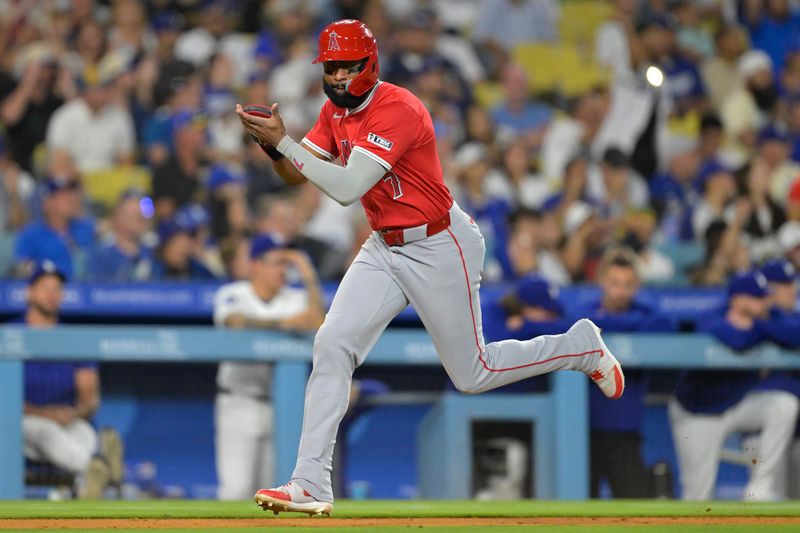 Jun 21, 2024; Los Angeles, California, USA;  Los Angeles Angels right fielder Jo Adell (7) runs home to score the winning run on a single by left fielder Taylor Ward (3) in the 10th inning against the Los Angeles Dodgers at Dodger Stadium. Mandatory Credit: Jayne Kamin-Oncea-USA TODAY Sports