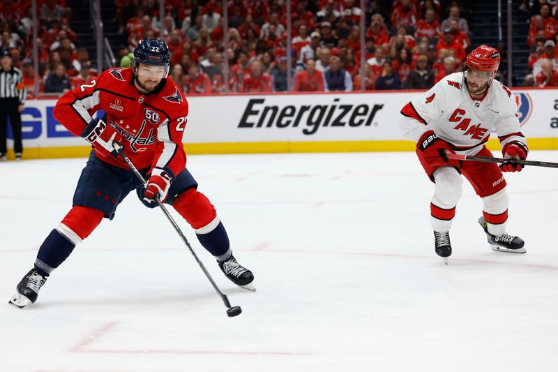 May 8, 2025; Washington, District of Columbia, USA; Washington Capitals right wing Brandon Duhaime (22) clears the puck from Carolina Hurricanes defenseman Shayne Gostisbehere (4) in the second period in game two of the second round of the 2025 Stanley Cup Playoffs at Capital One Arena. Mandatory Credit: Geoff Burke-Imagn Images