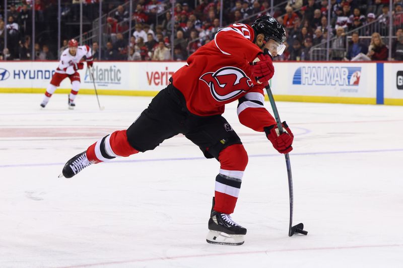 Nov 21, 2024; Newark, New Jersey, USA; New Jersey Devils left wing Tomas Tatar (90) shoots the puck against the Carolina Hurricanes during the second period at Prudential Center. Mandatory Credit: Ed Mulholland-Imagn Images