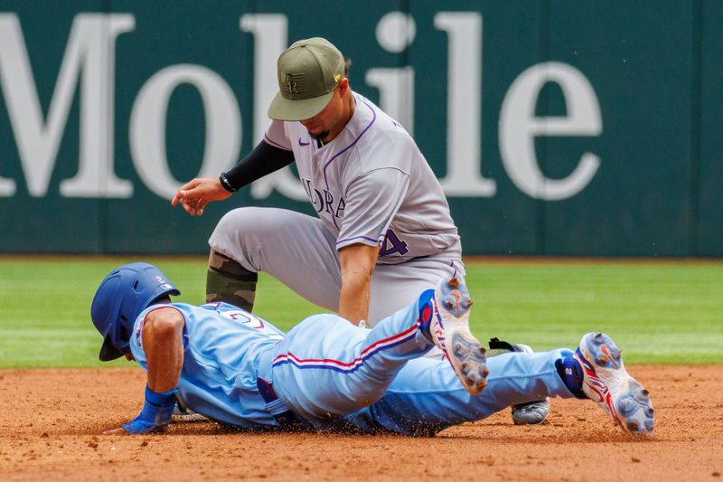 May 21, 2023; Arlington, Texas, USA; Texas Rangers second baseman Marcus Semien (2) slides in under a tag by Colorado Rockies shortstop Ezequiel Tovar (14) during the second inning at Globe Life Field. Mandatory Credit: Andrew Dieb-USA TODAY Sports