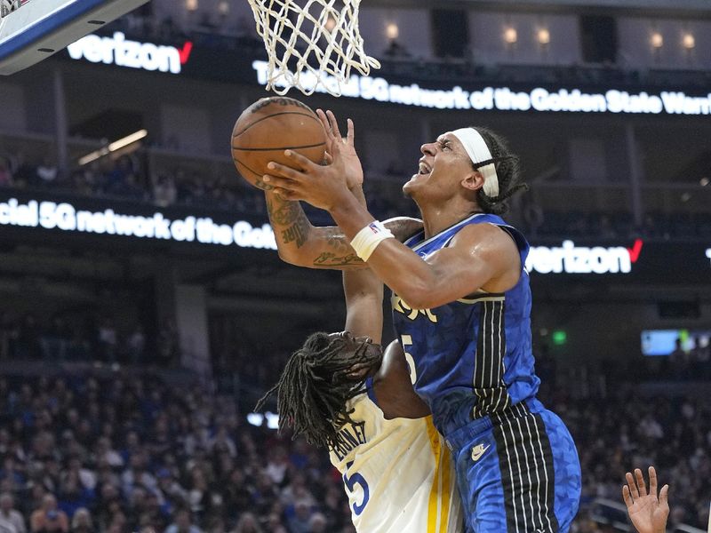 SAN FRANCISCO, CALIFORNIA - JANUARY 02: Paolo Banchero #5 of the Orlando Magic goes up to shoot and gets fouled by Kevon Looney #5 of the Golden State Warriors during the first quarter of an NBA basketball game at Chase Center on January 02, 2024 in San Francisco, California. NOTE TO USER: User expressly acknowledges and agrees that, by downloading and or using this photograph, User is consenting to the terms and conditions of the Getty Images License Agreement. (Photo by Thearon W. Henderson/Getty Images)