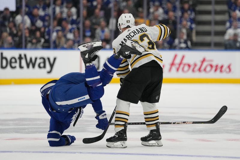 Apr 24, 2024; Toronto, Ontario, CAN; Boston Bruins forward Brad Marchand (63) trips up Toronto Maple Leafs forward Tyler Bertuzzi (59) during the second period of game three of the first round of the 2024 Stanley Cup Playoffs at Scotiabank Arena. Mandatory Credit: John E. Sokolowski-USA TODAY Sports