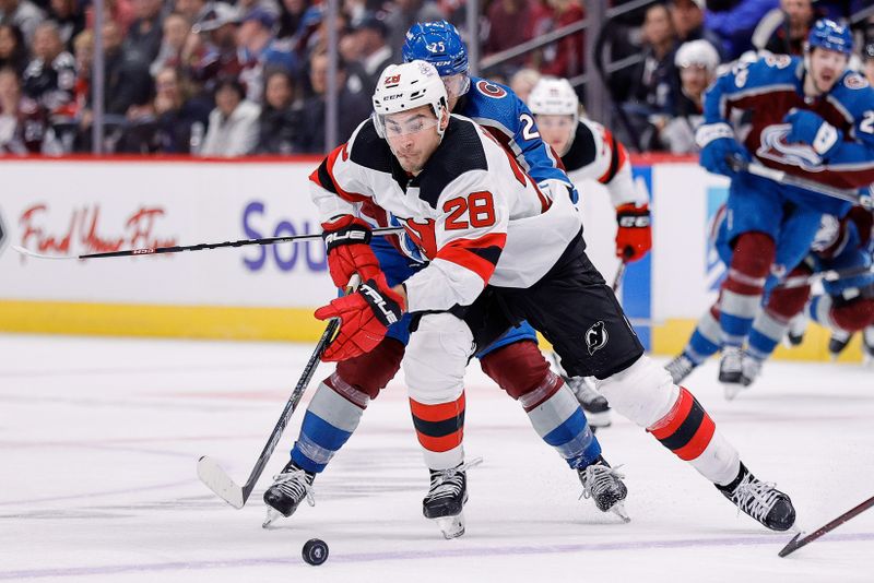 Nov 7, 2023; Denver, Colorado, USA; New Jersey Devils right wing Timo Meier (28) controls the puck ahead of Colorado Avalanche right wing Logan O'Connor (25) in the third period at Ball Arena. Mandatory Credit: Isaiah J. Downing-USA TODAY Sports