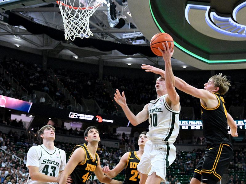 Dec 2, 2025; East Lansing, Michigan, USA;  Michigan State Spartans guard Denham Wojcik (10) gets fouled under the basket by Iowa Hawkeyes forward Cooper Koch (8) during the second half at Jack Breslin Student Events Center. Mandatory Credit: Dale Young-Imagn Images