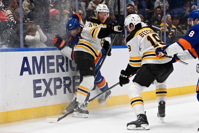 Nov 27, 2024; Elmont, New York, USA;  Boston Bruins left wing Cole Koepke (45) checks New York Islanders defenseman Alexander Romanov (28) into the boards during the first period at UBS Arena. Mandatory Credit: Dennis Schneidler-Imagn Images