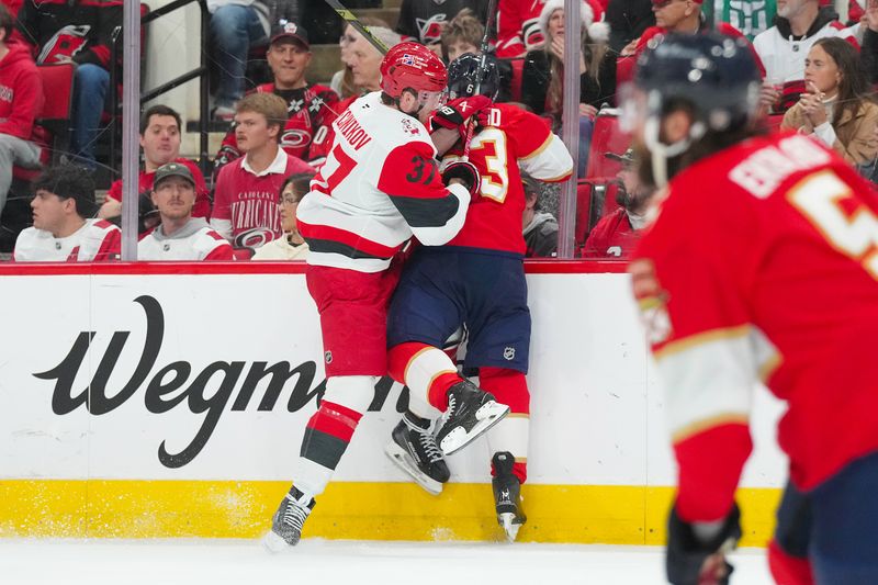 Dec 23, 2025; Raleigh, North Carolina, USA;  Carolina Hurricanes right wing Andrei Svechnikov (37) checks Florida Panthers left wing Brad Marchand (63) during the first period at Lenovo Center. Mandatory Credit: James Guillory-Imagn Images