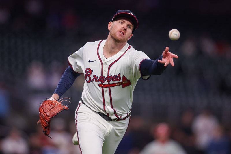 Apr 10, 2025; Atlanta, Georgia, USA; Atlanta Braves relief pitcher Aaron Bummer (49) throws a runner out at first against the Philadelphia Phillies in the seventh inning at Truist Park. Mandatory Credit: Brett Davis-Imagn Images
