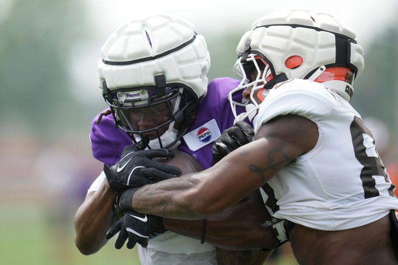 Minnesota Vikings safety Lewis Cine, left, intercepts a pass intended for Cleveland Browns tight end Zaire Mitchell-Paden, right, during a joint NFL football practice, Thursday, Aug. 15, 2024, in Berea, Ohio. (AP Photo/Sue Ogrocki)