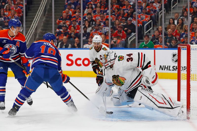 Oct 12, 2024; Edmonton, Alberta, CAN; Chicago Blackhawks goaltender Petr Mrazek (34) makes a save on Edmonton Oilers forward Zach Hyman (18) during the first period at Rogers Place. Mandatory Credit: Perry Nelson-Imagn Images