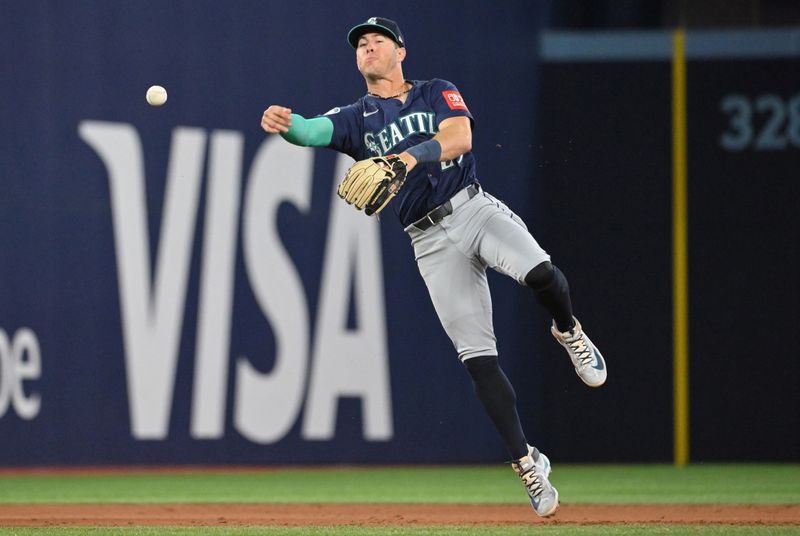 Apr 20, 2025; Toronto, Ontario, CAN;  Seattle Mariners shortstop Ryan Moore (25) throws out Toronto Blue Jays center fielder George Springer (not shown) in the fourth inning at Rogers Centre. Mandatory Credit: Dan Hamilton-Imagn Images