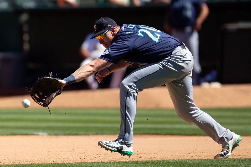 Sep 5, 2024; Oakland, California, USA; Seattle Mariners first baseman Luke Raley (20) attempts to field a ball hit by Oakland Athletics right fielder Lawrence Butler (not pictured) during the seventh inning at Oakland-Alameda County Coliseum. Mandatory Credit: D. Ross Cameron-Imagn Images