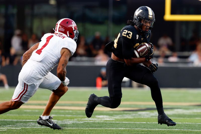 Oct 5, 2024; Nashville, Tennessee, USA;  Vanderbilt Commodores running back AJ Newberry (23) runs the ball against Alabama Crimson Tide defensive back Domani Jackson (1) during the second half at FirstBank Stadium. Mandatory Credit: Butch Dill-Imagn Images