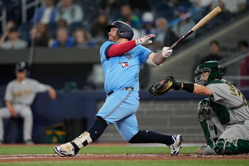 May 29, 2025; Toronto, Ontario, CAN; Toronto Blue Jays catcher Alejandro Kirk (30) hits a single against the Athletics during the second inning at Rogers Centre. Mandatory Credit: John E. Sokolowski-Imagn Images