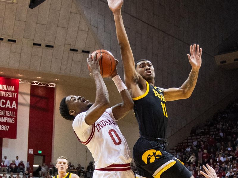 Jan 30, 2024; Bloomington, Indiana, USA; Indiana Hoosiers guard Xavier Johnson (0) shoots the ball while Iowa Hawkeyes guard Tony Perkins (11) defends in the first half at Simon Skjodt Assembly Hall. Mandatory Credit: Trevor Ruszkowski-USA TODAY Sports