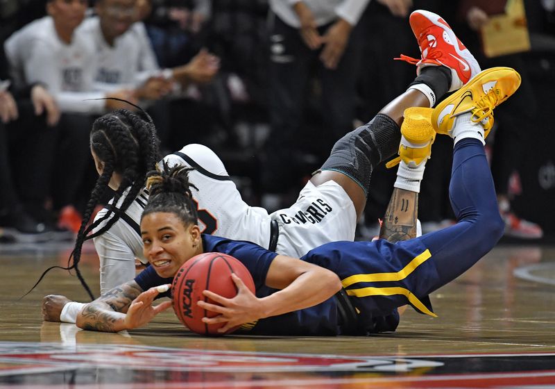 Mar 10, 2023; Kansas City, MO, USA;  West Virginia Mountaineers guard JJ Quinerly (11) dives after the ball against Oklahoma State Cowgirls guard Naomie Alnatas (3) during the first half at Municipal Auditorium. Mandatory Credit: Peter Aiken-USA TODAY Sports