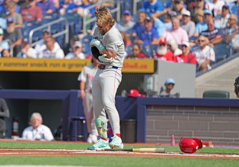 Sep 4, 2024; Toronto, Ontario, CAN; Philadelphia Phillies first baseman Bryce Harper (3) reacts after getting hit with a pitch against the Toronto Blue Jays during the first inning at Rogers Centre. Mandatory Credit: Nick Turchiaro-Imagn Images