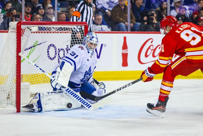 Jan 18, 2024; Calgary, Alberta, CAN; Toronto Maple Leafs goaltender Martin Jones (31) makes a save against Calgary Flames center Nazem Kadri (91) during the second period at Scotiabank Saddledome. Mandatory Credit: Sergei Belski-USA TODAY Sports