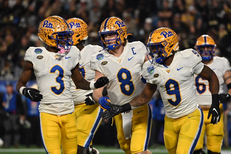 Dec 4, 2021; Charlotte, NC, USA; Pittsburgh Panthers running back Rodney Hammond Jr. (9) celebrates with quarterback Kenny Pickett (8) and wide receiver Jordan Addison (3) in the first quarter of the ACC championship game at Bank of America Stadium. Mandatory Credit: Bob Donnan-USA TODAY Sports