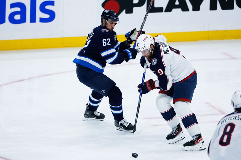 Nov 18, 2025; Winnipeg, Manitoba, CAN;  Columbus Blue Jackets defenseman Ivan Provorov (9) skates past Winnipeg Jets forward Nino Niederreiter (62) during the second period at Canada Life Centre. Mandatory Credit: Terrence Lee-Imagn Images