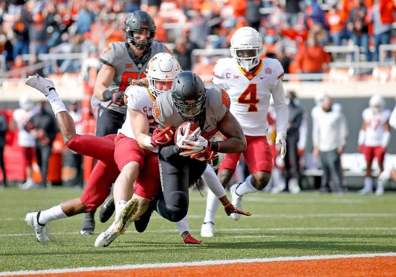 Oct 24, 2020; Stillwater, Oklahoma, USA;  Oklahoma State Cowboys player Jelani Woods (89) scores a touchdown as Iowa State Cyclones player Mike Rose defends in the first quarter at Boone Pickens Stadium. Mandatory Credit: Sarah Phipps-USA TODAY Sports