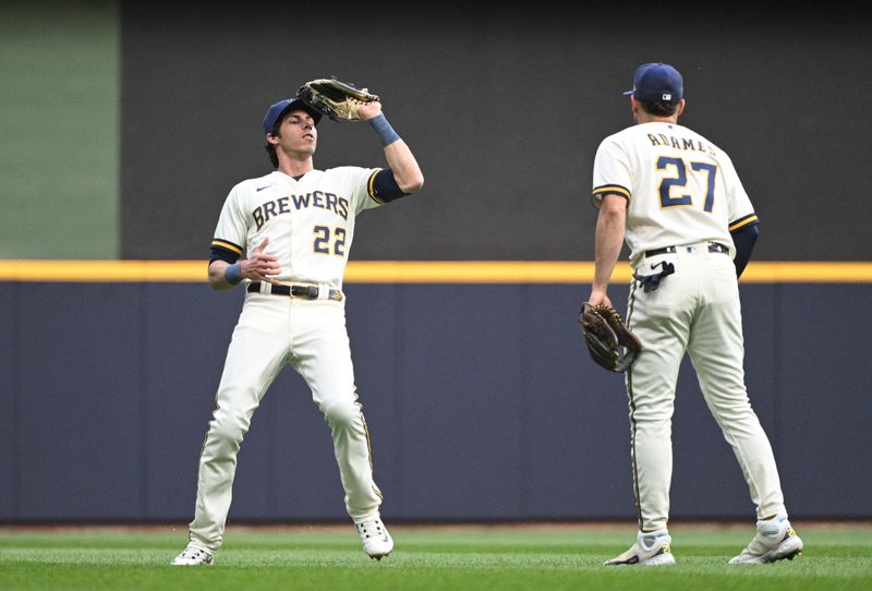 May 23, 2023; Milwaukee, Wisconsin, USA; Milwaukee Brewers left fielder Christian Yelich (22) makes a catch as Milwaukee Brewers shortstop Willy Adames (27) looks on against the Houston Astros in the third inning at American Family Field. Mandatory Credit: Michael McLoone-USA TODAY Sports