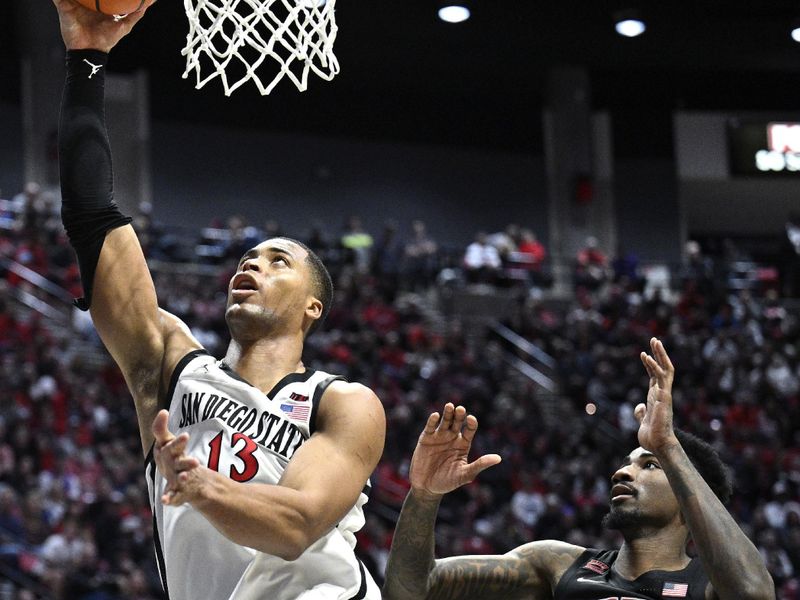 Jan 6, 2024; San Diego, California, USA; San Diego State Aztecs forward Jaedon LeDee (13) goes to the basket past UNLV Rebels forward Kalib Boone (10) during the second half at Viejas Arena. Mandatory Credit: Orlando Ramirez-USA TODAY Sports