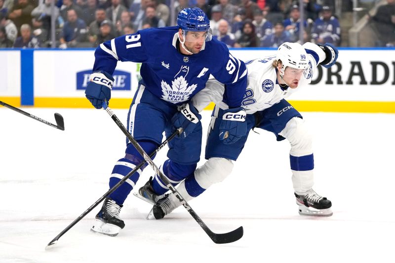 Oct 21, 2024; Toronto, Ontario, CAN; Tampa Bay Lightning defenseman Janis Moser (90) and Toronto Maple Leafs forward John Tavares (91) battle for position during the first period at Scotiabank Arena. Mandatory Credit: John E. Sokolowski-Imagn Images