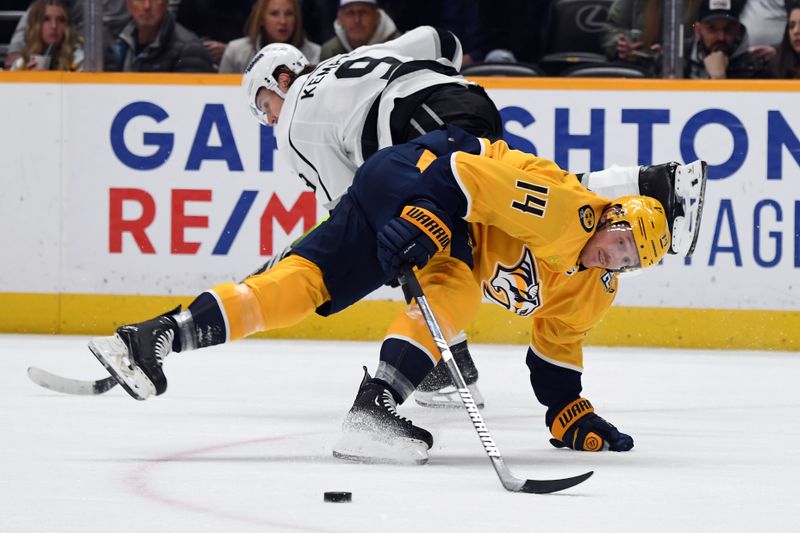 Jan 31, 2024; Nashville, Tennessee, USA; Nashville Predators center Gustav Nyquist (14) loses the puck as he is hit by Los Angeles Kings right wing Adrian Kempe (9) during the first period at Bridgestone Arena. Mandatory Credit: Christopher Hanewinckel-USA TODAY Sports