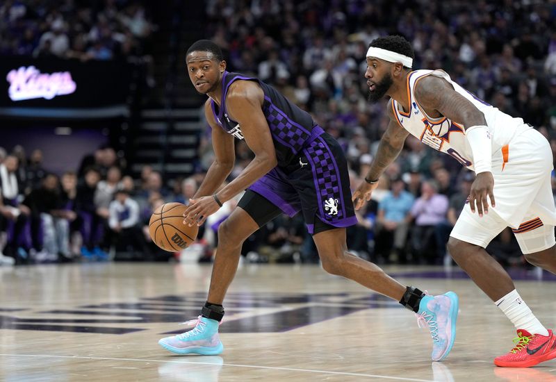 SACRAMENTO, CALIFORNIA - APRIL 12: De'Aaron Fox #5 of the Sacramento Kings dribbling the ball is guarded by Royce O'Neale #00 of the Phoenix Suns during the second half of an NBA basketball game at Golden 1 Center on April 12, 2024 in Sacramento, California. NOTE TO USER: User expressly acknowledges and agrees that, by downloading and or using this photograph, User is consenting to the terms and conditions of the Getty Images License Agreement. (Photo by Thearon W. Henderson/Getty Images)