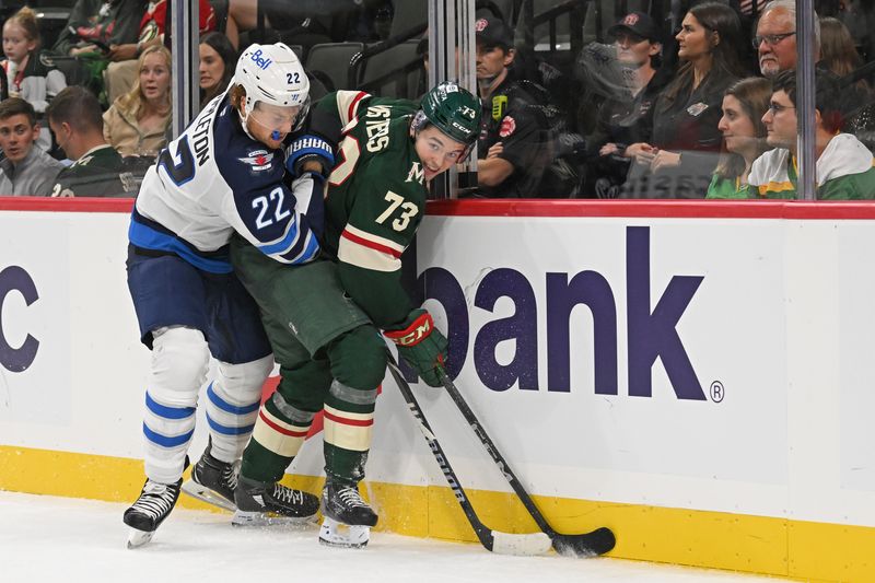 Sep 27, 2024; Saint Paul, Minnesota, USA;  Winnipeg Jets forward Mason Appleton (22) and Minnesota Wild defenseman Kyle Masters (73) battle for the puck along the boards during the third period at Xcel Energy Center. Mandatory Credit: Nick Wosika-Imagn Images

