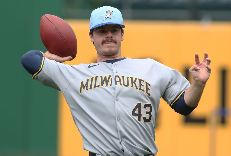 May 23, 2025; Pittsburgh, Pennsylvania, USA;  Milwaukee Brewers pitcher Logan Henderson (43) tosses a football to warm up before the game against the Pittsburgh Pirates at PNC Park. Mandatory Credit: Charles LeClaire-Imagn Images