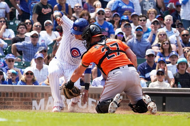 Jun 17, 2023; Chicago, Illinois, USA; Chicago Cubs catcher Yan Gomes (15) is  safe at home plate as Baltimore Orioles catcher James McCann (27) makes a late tag during the fifth inning at Wrigley Field. Mandatory Credit: David Banks-USA TODAY Sports