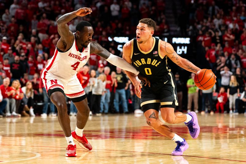 Jan 9, 2024; Lincoln, Nebraska, USA; Purdue Boilermakers forward Mason Gillis (0) drives against Nebraska Cornhuskers forward Juwan Gary (4) during the second half at Pinnacle Bank Arena. Mandatory Credit: Dylan Widger-USA TODAY Sports