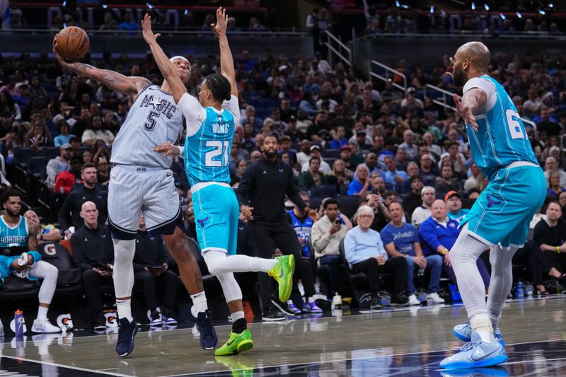 ORLANDO, FLORIDA - FEBRUARY 12: Paolo Banchero #5 of the Orlando Magic throws a pass over Isaiah Wong #21 of the Charlotte Hornets during the fourth quarter at Kia Center on February 12, 2025 in Orlando, Florida. NOTE TO USER: User expressly acknowledges and agrees that, by downloading and or using this photograph, user is consenting to the terms and conditions of the Getty Images License Agreement. (Photo by Rich Storry/Getty Images)