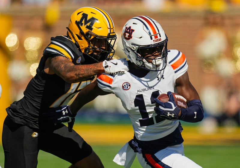 Oct 19, 2024; Columbia, Missouri, USA; Auburn Tigers quarterback Walker White (11) runs the ball against Missouri Tigers cornerback Dreyden Norwood (12) during the first half at Faurot Field at Memorial Stadium. Mandatory Credit: Jay Biggerstaff-Imagn Images