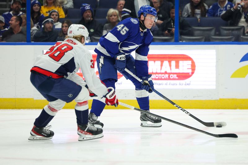 Feb 22, 2024; Tampa, Florida, USA;  Tampa Bay Lightning left wing Cole Koepke (45) controls the puck from Washington Capitals defenseman Rasmus Sandin (38) in the first period at Amalie Arena. Mandatory Credit: Nathan Ray Seebeck-USA TODAY Sports