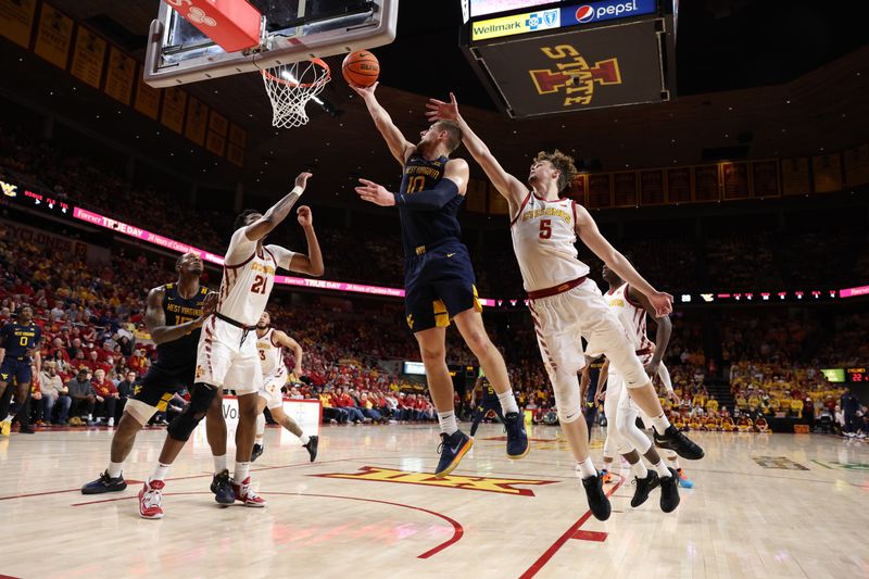 Feb 27, 2023; Ames, Iowa, USA; West Virginia Mountaineers guard Erik Stevenson (10) beats Iowa State Cyclones forward Aljaz Kunc (5) to the basket during the first half at James H. Hilton Coliseum. Mandatory Credit: Reese Strickland-USA TODAY Sports