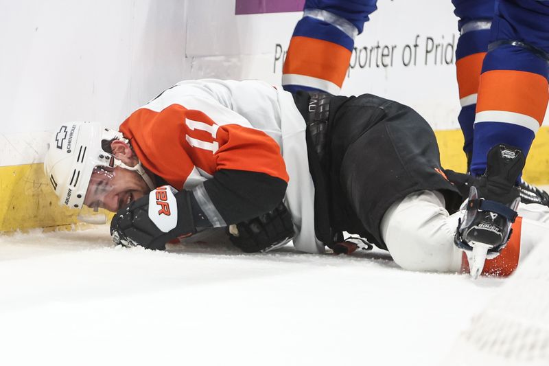 Jan 16, 2025; Elmont, New York, USA;  Philadelphia Flyers right wing Travis Konecny (11) lays on the ice after colliding into the wall in the first period at UBS Arena. Mandatory Credit: Wendell Cruz-Imagn Images