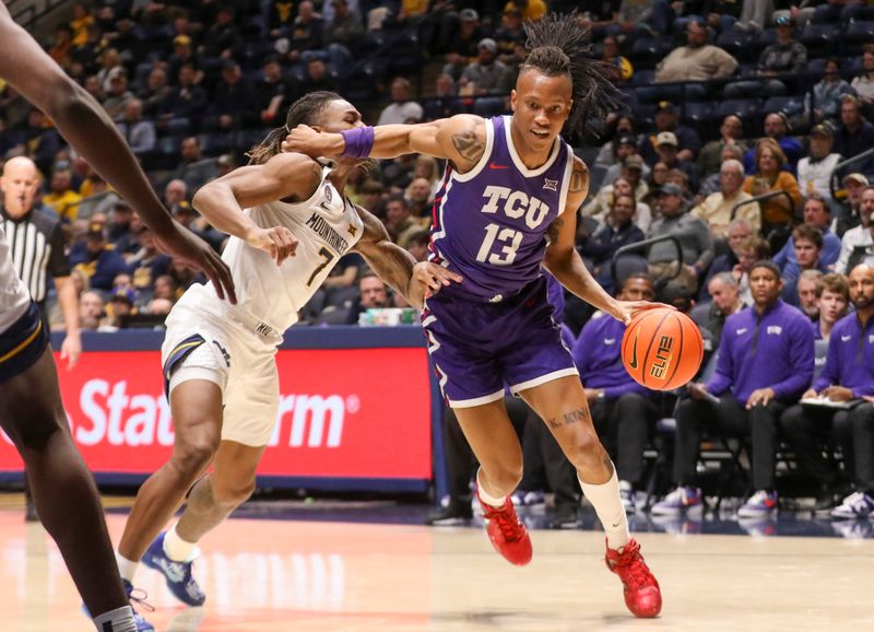 Feb 25, 2025; Morgantown, West Virginia, USA; TCU Horned Frogs forward Trazarien White (13) drives past West Virginia Mountaineers guard Javon Small (7) during the second half at WVU Coliseum. Mandatory Credit: Ben Queen-Imagn Images