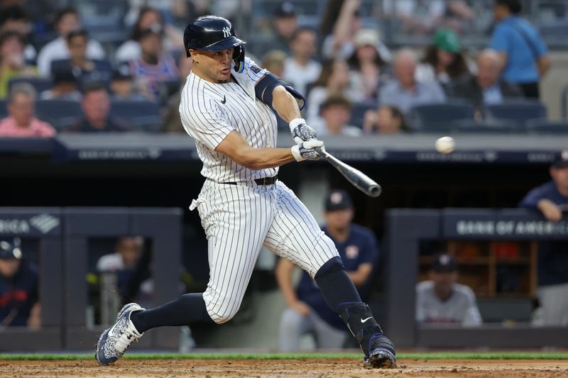May 8, 2024; Bronx, New York, USA; New York Yankees designated hitter Giancarlo Stanton (27) hits a solo home run against the Houston Astros during the third inning at Yankee Stadium. Mandatory Credit: Brad Penner-USA TODAY Sports