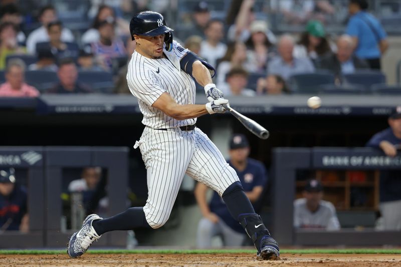 May 8, 2024; Bronx, New York, USA; New York Yankees designated hitter Giancarlo Stanton (27) hits a solo home run against the Houston Astros during the third inning at Yankee Stadium. Mandatory Credit: Brad Penner-USA TODAY Sports