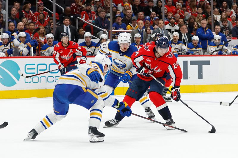 Nov 22, 2023; Washington, District of Columbia, USA; Washington Capitals center Connor McMichael (24) skates with the puck as Buffalo Sabres defenseman Henri Jokiharju (10) defends in the third period at Capital One Arena. Mandatory Credit: Geoff Burke-USA TODAY Sports