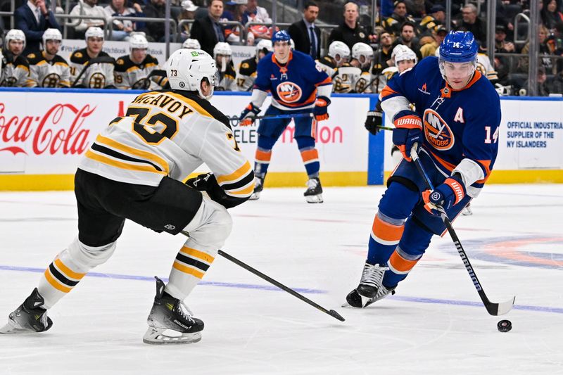 Nov 27, 2024; Elmont, New York, USA;  New York Islanders center Bo Horvat (14) skates across the blue line defended by Boston Bruins defenseman Charlie McAvoy (73) during the second period at UBS Arena. Mandatory Credit: Dennis Schneidler-Imagn Images