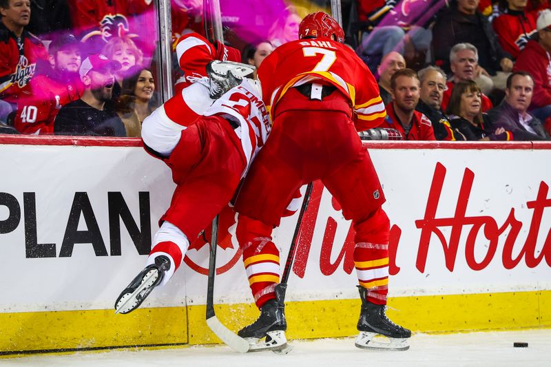 Dec 10, 2025; Calgary, Alberta, CAN; Calgary Flames defenseman Kevin Bahl (7) checks into the boards Detroit Red Wings left wing J.T. Compher (37) during the third period at Scotiabank Saddledome. Mandatory Credit: Sergei Belski-Imagn Images