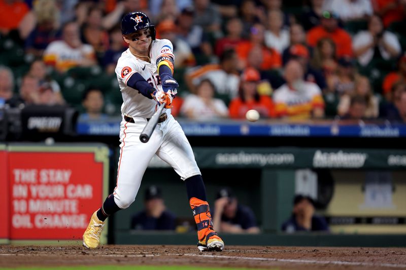 Sep 25, 2024; Houston, Texas, USA; Houston Astros left fielder Mauricio DubÛn (14) hits a single against the Seattle Mariners during the second inning at Minute Maid Park. Mandatory Credit: Erik Williams-Imagn Images