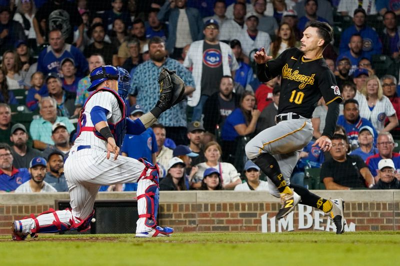 Sep 21, 2023; Chicago, Illinois, USA; Chicago Cubs catcher Yan Gomes (15) tags out Pittsburgh Pirates left fielder Bryan Reynolds (10) at home plate during the ninth inning  at Wrigley Field. Mandatory Credit: David Banks-USA TODAY Sports