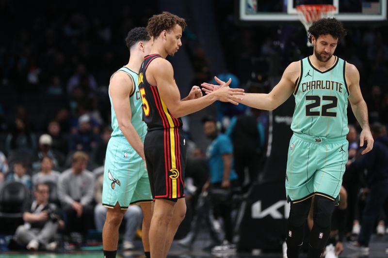 CHARLOTTE, NC - NOVEMBER 30: Dyson Daniels #5 of the Atlanta Hawks and Vasilije Micic #22 of the Charlotte Hornets  high five during the game on November 30, 2024 at Spectrum Center in Charlotte, North Carolina. NOTE TO USER: User expressly acknowledges and agrees that, by downloading and or using this photograph, User is consenting to the terms and conditions of the Getty Images License Agreement. Mandatory Copyright Notice: Copyright 2024 NBAE (Photo by Brock Williams-Smith/NBAE via Getty Images)